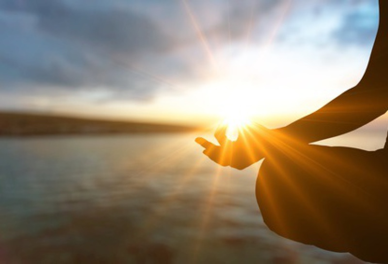 Mensch entspannt bei Atemübung im Sonnenlicht – Stressbewältigung und Entspannung