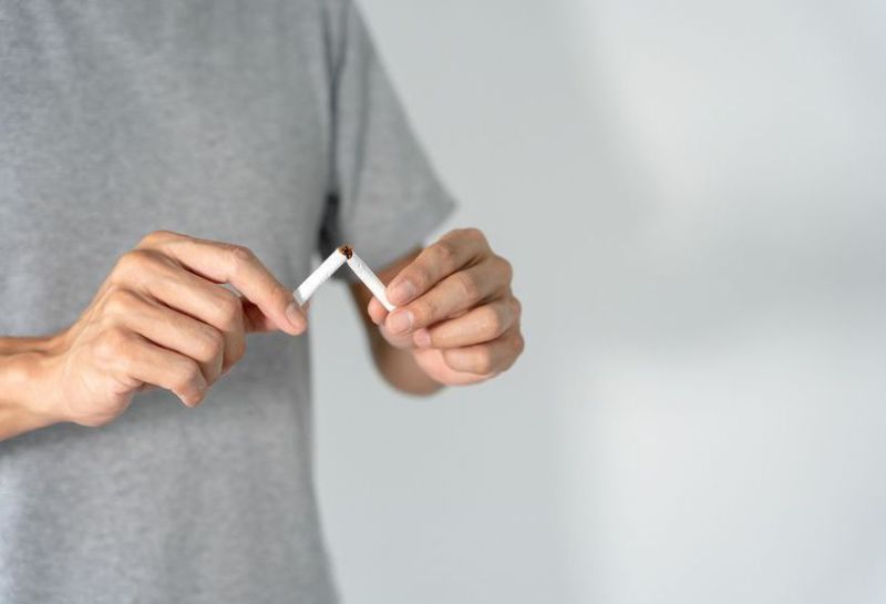 Mann hört mit dem Rauchen auf und zerbricht eine Zigarette